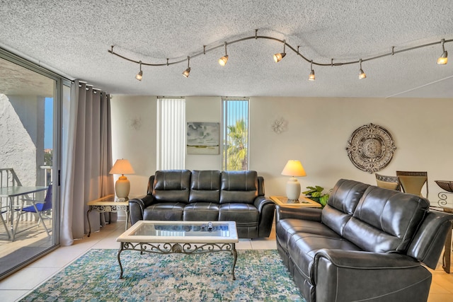 living room featuring rail lighting, a textured ceiling, and light tile flooring