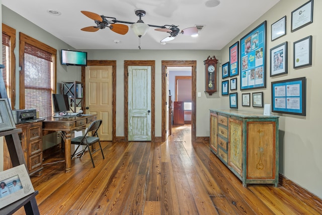 home office featuring ceiling fan and dark wood-type flooring