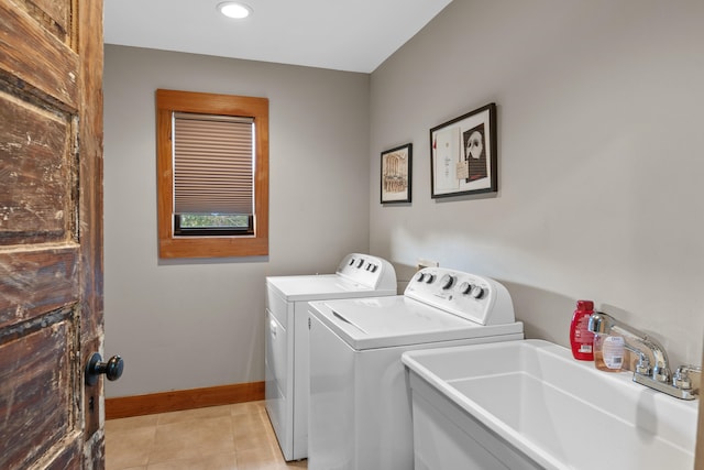 laundry room featuring sink, washer and dryer, and light tile flooring