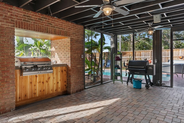 view of terrace with ceiling fan, grilling area, and an outdoor kitchen