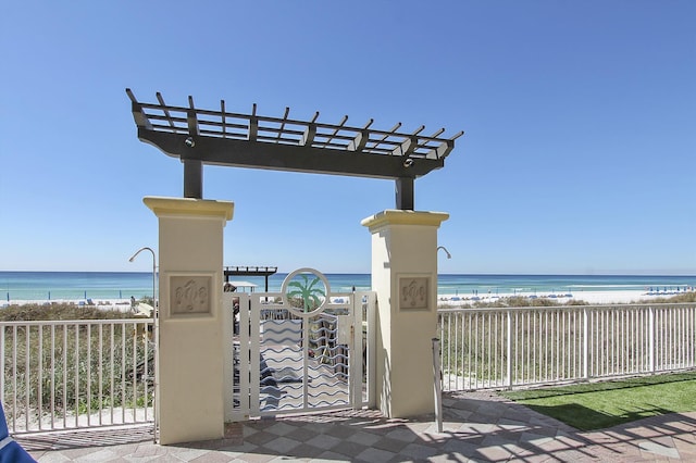 surrounding community featuring a water view, a beach view, and a pergola