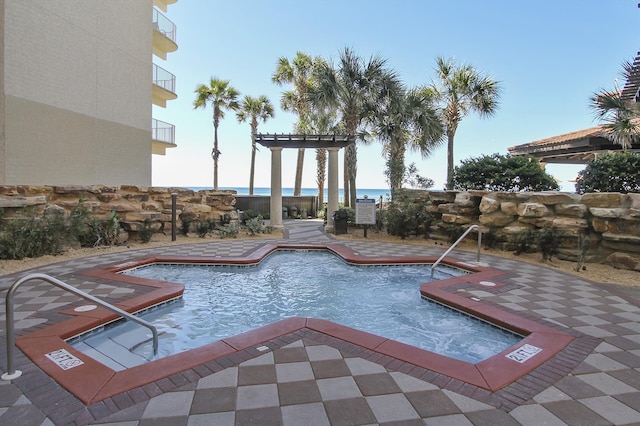 community pool with a patio area and a pergola