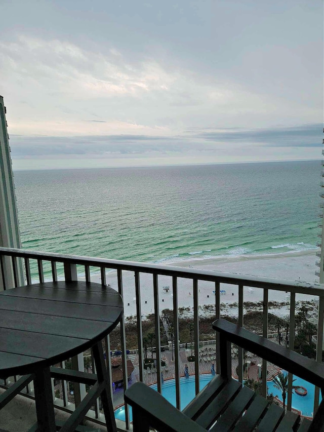 balcony with a water view and a beach view