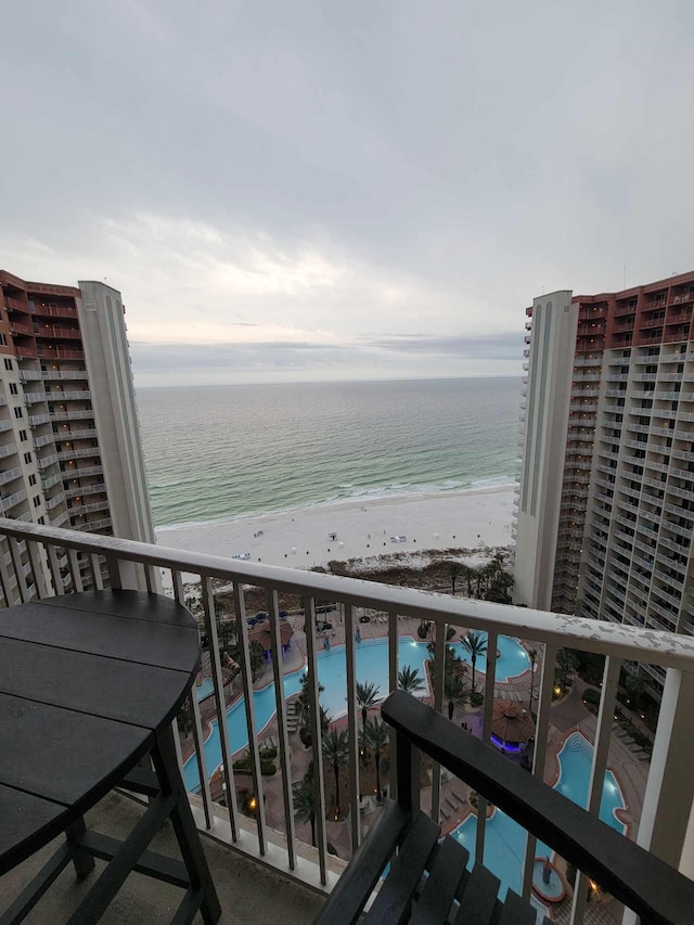 balcony featuring a beach view and a water view