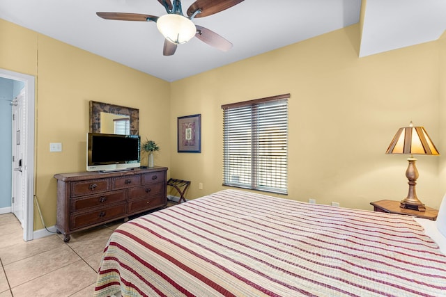 bedroom with a ceiling fan, baseboards, and light tile patterned floors