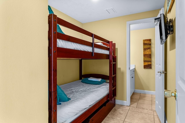 bedroom featuring light tile patterned floors, visible vents, and baseboards