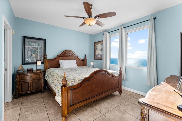 tiled bedroom featuring a water view and ceiling fan