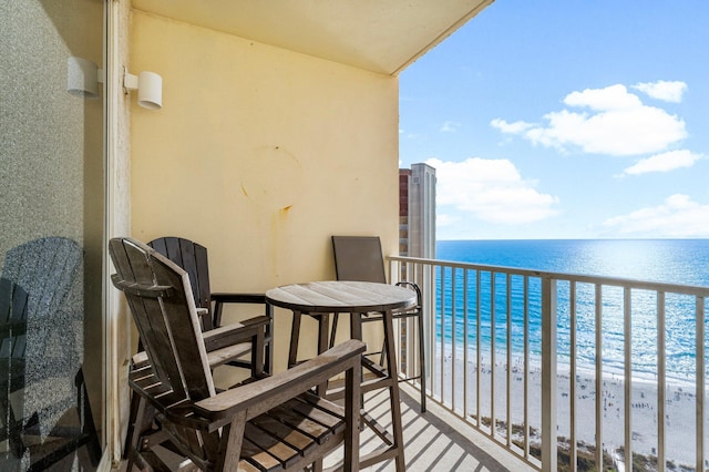 balcony with a water view and a view of the beach