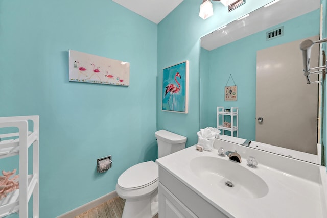 bathroom with hardwood / wood-style flooring, toilet, and oversized vanity