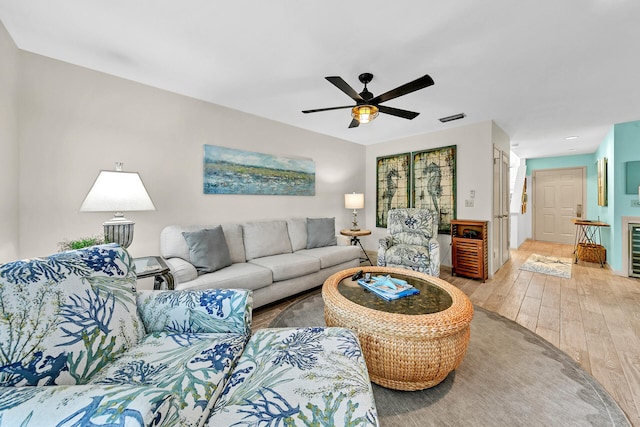 living room with light hardwood / wood-style flooring, ceiling fan, and wine cooler