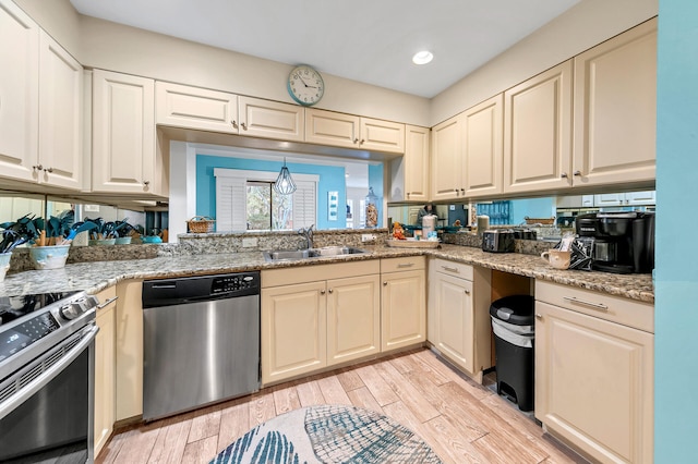 kitchen featuring light stone countertops, sink, stainless steel appliances, and light hardwood / wood-style floors