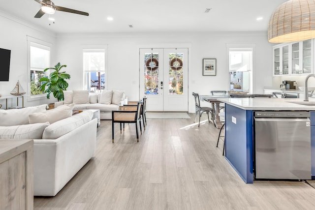 living room featuring french doors, light hardwood / wood-style flooring, ceiling fan, and a wealth of natural light