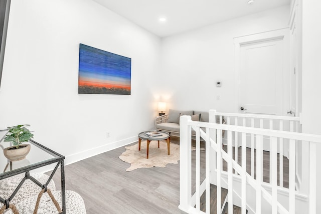 bedroom featuring wood-type flooring and a nursery area