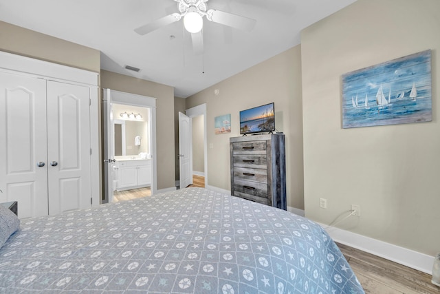 bedroom featuring a closet, ensuite bath, ceiling fan, and dark wood-type flooring