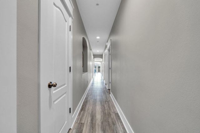 corridor with hardwood / wood-style flooring