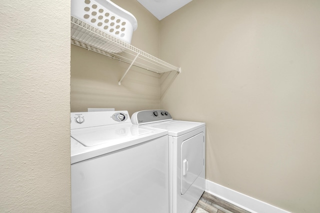 laundry area with separate washer and dryer and light wood-type flooring