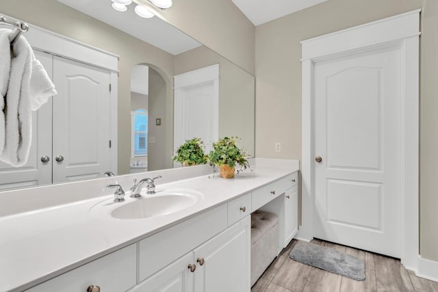 bathroom with hardwood / wood-style floors and large vanity