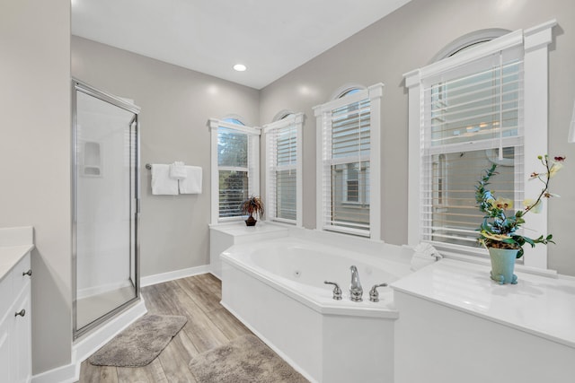 bathroom featuring wood-type flooring, vanity, and shower with separate bathtub