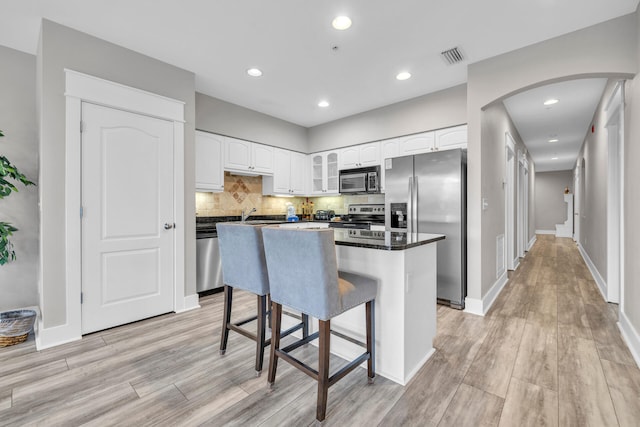 kitchen with light hardwood / wood-style floors, white cabinetry, and stainless steel appliances