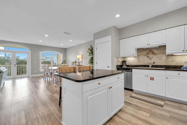 kitchen featuring a kitchen island, french doors, white cabinets, and stainless steel dishwasher