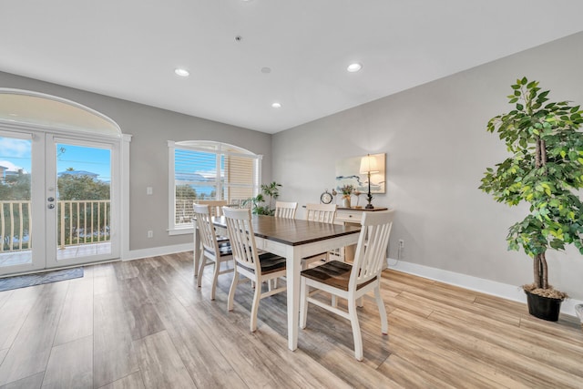 dining area with french doors and light hardwood / wood-style floors