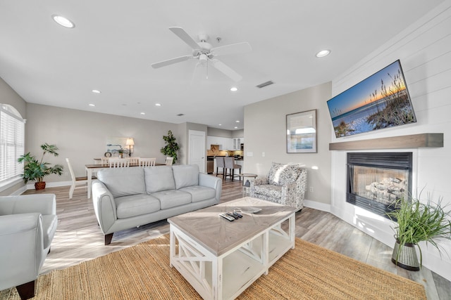 living room with ceiling fan and light wood-type flooring