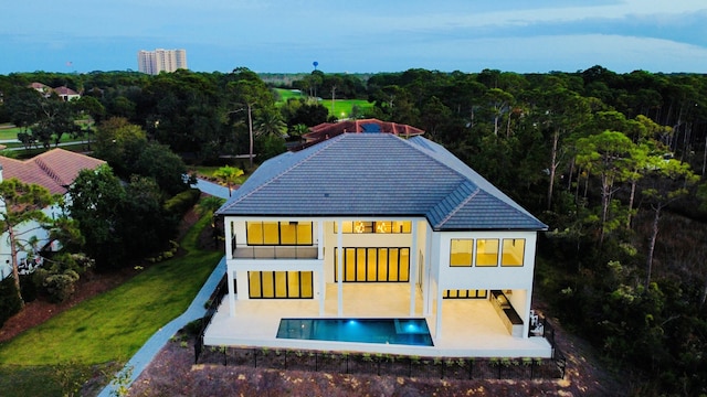 330 Kelly Plantation Dr, Destin, FL 32541 - back of property featuring an outdoor pool, a patio area, a balcony, a wooded view, and a tiled roof