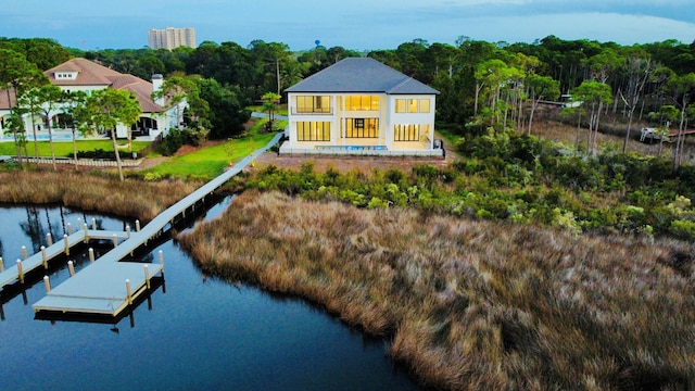 rear view of property featuring a water view and a balcony