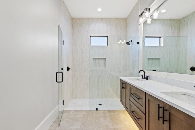 bathroom featuring tile patterned flooring, vanity, a healthy amount of sunlight, and a shower with shower door