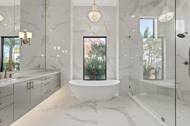 bathroom with vanity, independent shower and bath, and a notable chandelier