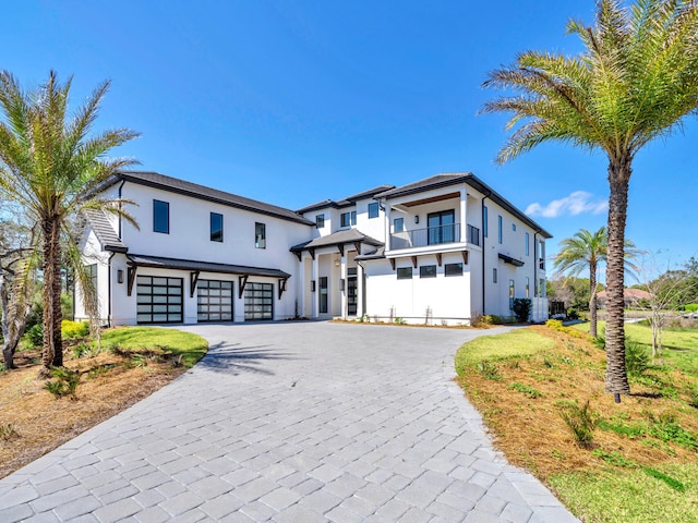 330 Kelly Plantation Dr, Destin, FL 32541 - view of front of property with an attached garage, a balcony, stucco siding, and decorative driveway