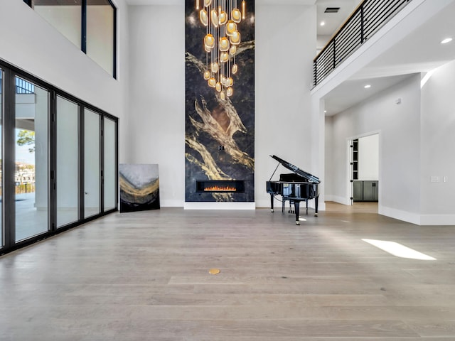 330 Kelly Plantation Dr, Destin, FL 32541 - entryway with a towering ceiling, baseboards, wood finished floors, a premium fireplace, and a chandelier
