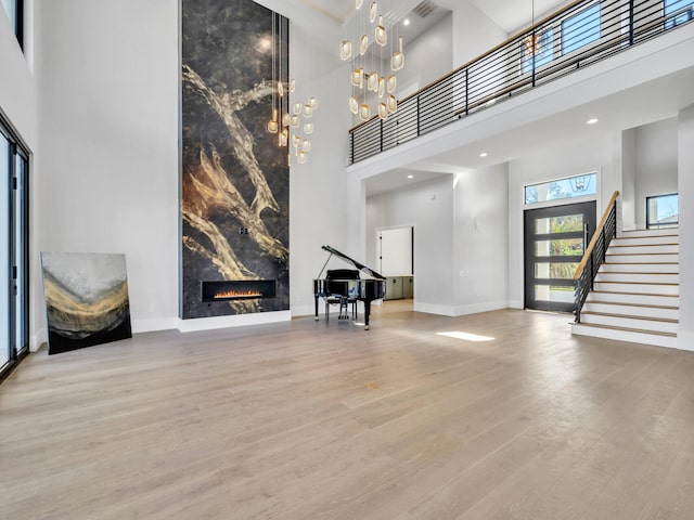 330 Kelly Plantation Dr, Destin, FL 32541 - unfurnished living room with a towering ceiling, stairway, wood finished floors, a high end fireplace, and baseboards
