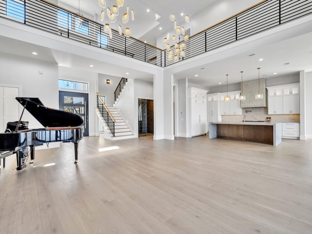 330 Kelly Plantation Dr, Destin, FL 32541 - living room featuring a high ceiling, a chandelier, light wood finished floors, stairs, and recessed lighting
