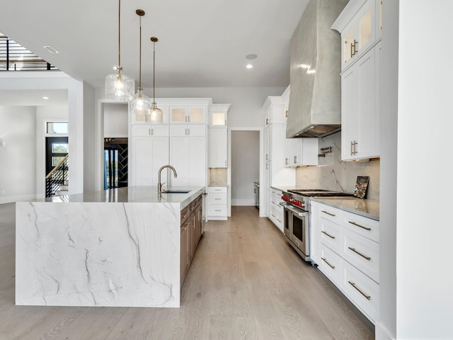 330 Kelly Plantation Dr, Destin, FL 32541 - kitchen with range with two ovens, wall chimney exhaust hood, a sink, a spacious island, and backsplash