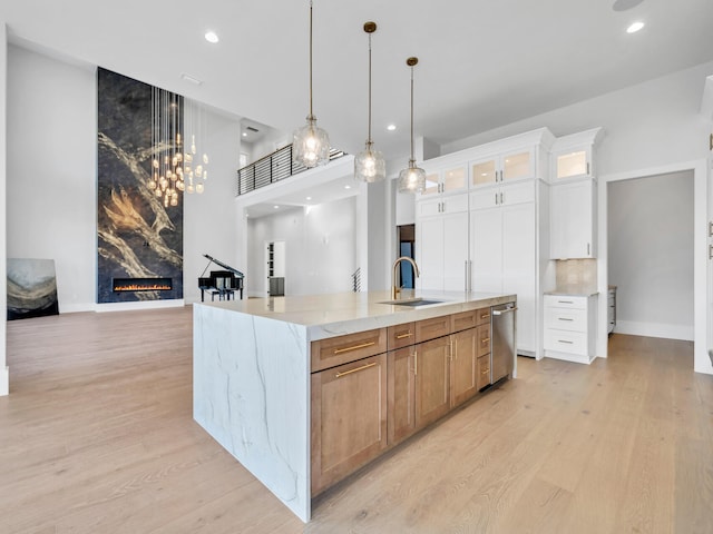 330 Kelly Plantation Dr, Destin, FL 32541 - kitchen with stainless steel dishwasher, a fireplace, light wood finished floors, light stone counters, and hanging light fixtures