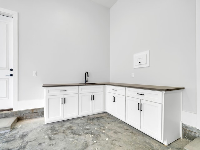330 Kelly Plantation Dr, Destin, FL 32541 - kitchen with a sink, unfinished concrete flooring, dark countertops, and white cabinets