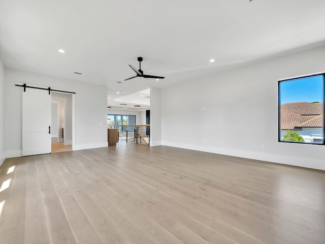 330 Kelly Plantation Dr, Destin, FL 32541 - unfurnished living room with a ceiling fan, light wood finished floors, a barn door, baseboards, and recessed lighting