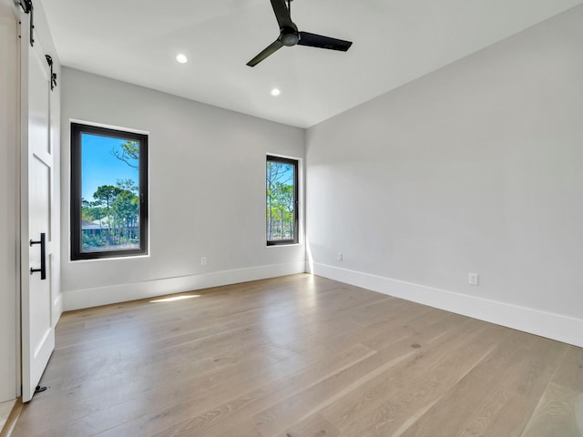 330 Kelly Plantation Dr, Destin, FL 32541 - unfurnished room with a barn door, recessed lighting, baseboards, light wood-style floors, and ceiling fan