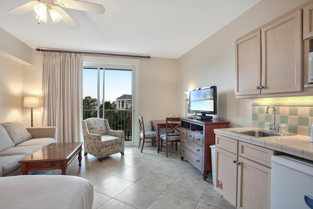 interior space featuring ceiling fan, sink, backsplash, light tile flooring, and tile counters