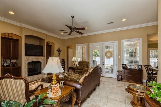 tiled living room featuring ceiling fan, crown molding, and french doors