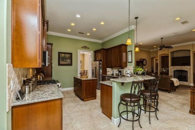 kitchen with decorative light fixtures, ceiling fan, light tile flooring, and light stone countertops