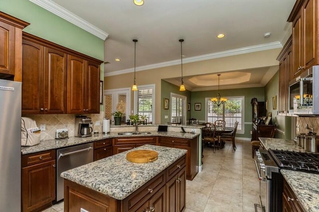 kitchen featuring light stone counters, appliances with stainless steel finishes, a notable chandelier, tasteful backsplash, and decorative light fixtures