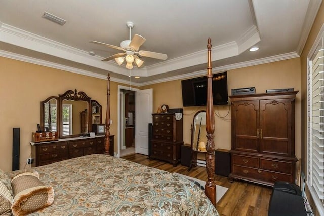 bedroom with ceiling fan, crown molding, a raised ceiling, and dark hardwood / wood-style floors