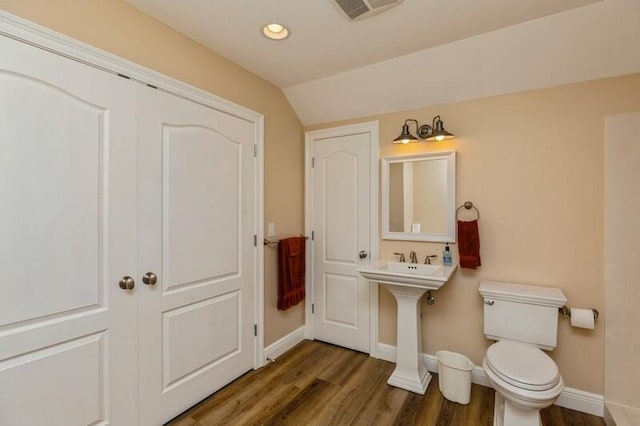 bathroom featuring lofted ceiling, hardwood / wood-style flooring, and toilet