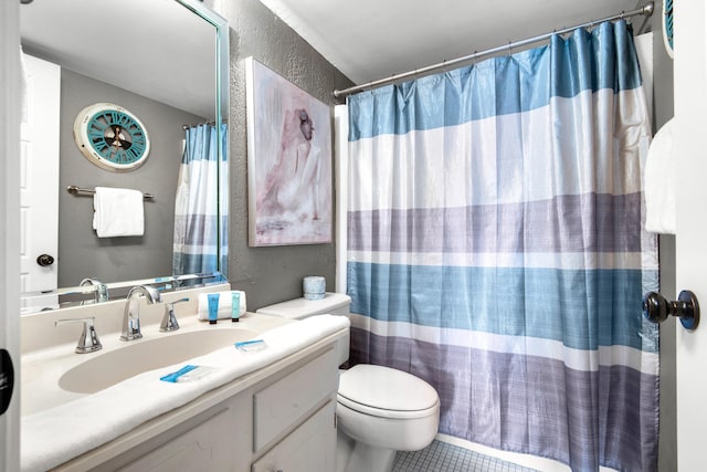 bathroom featuring tile flooring, vanity, and toilet