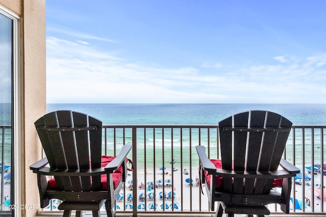 balcony featuring a water view and a beach view