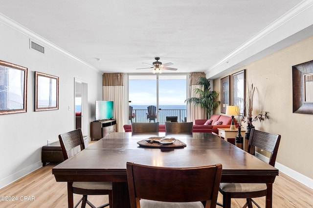 dining room featuring light wood-type flooring, ceiling fan, and crown molding