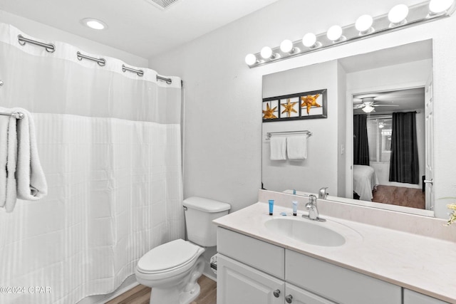 bathroom featuring hardwood / wood-style floors, vanity, a shower with curtain, ceiling fan, and toilet