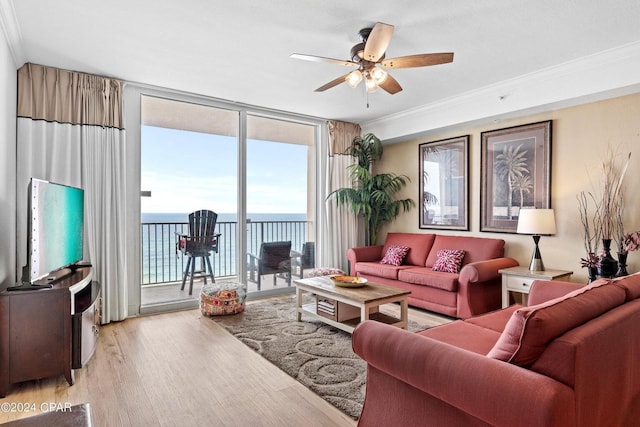 living room with ceiling fan, crown molding, expansive windows, and light hardwood / wood-style floors